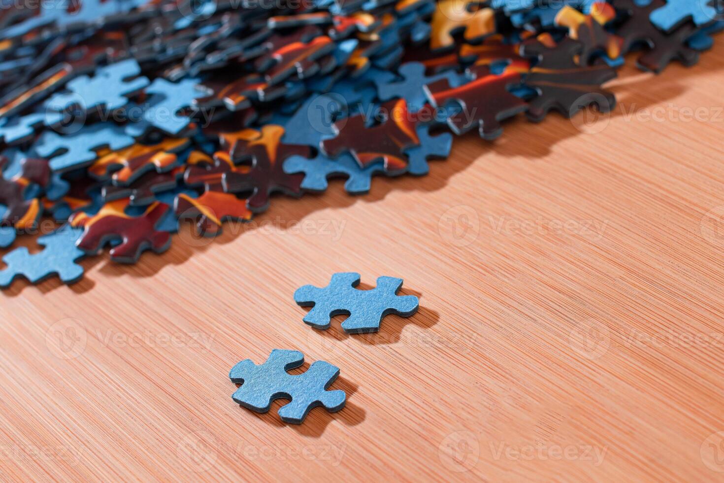 Colorful Pieces of a Mixed Jigsaw Puzzle Lie on the Wooden Table - Strategy and Solving Problem Concept photo