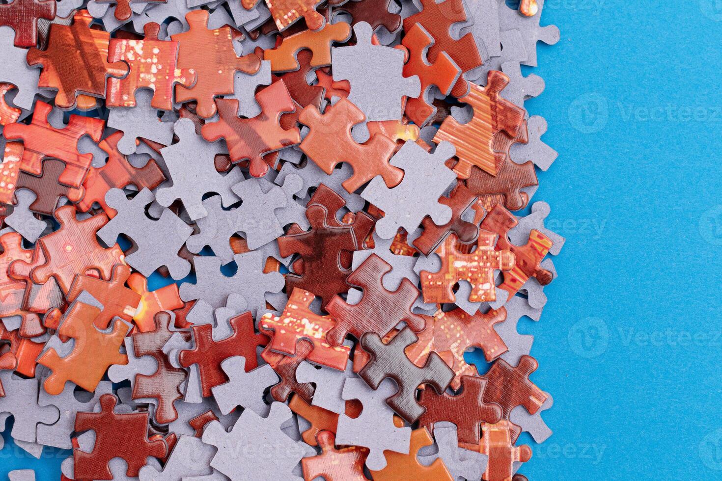 Mixed Pieces of a Colorful Jigsaw Puzzle Lie on the Blue Background - Strategy and Solving Problem Concept photo