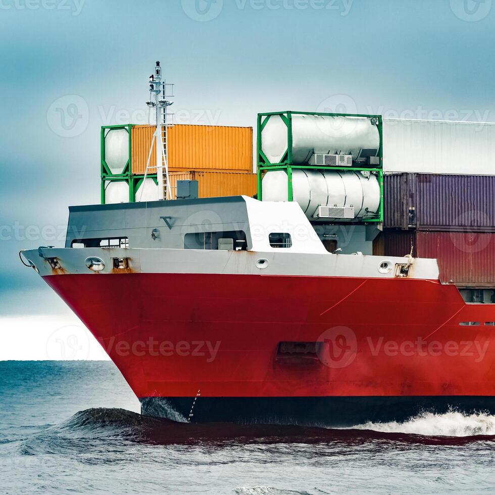 Red cargo container ship's bow in cloudy day photo