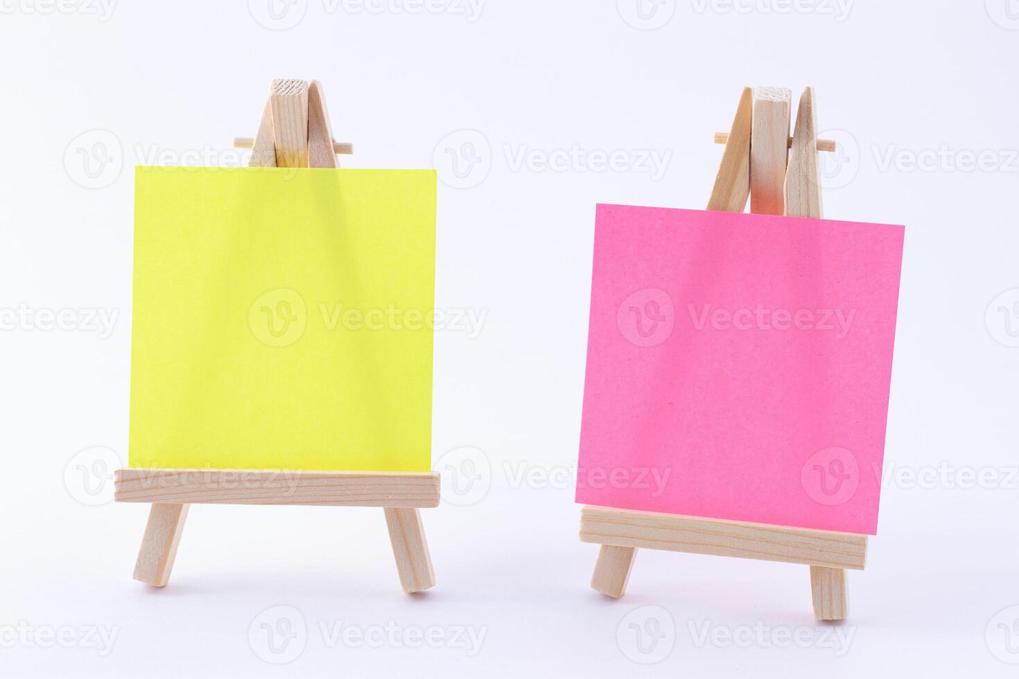 Two Wooden Easels Miniature with Blank Colored Square Canvas or Memo Paper - Mockup. Mini Wooden Stand with Clean Artboard on White Background, Copy Space photo