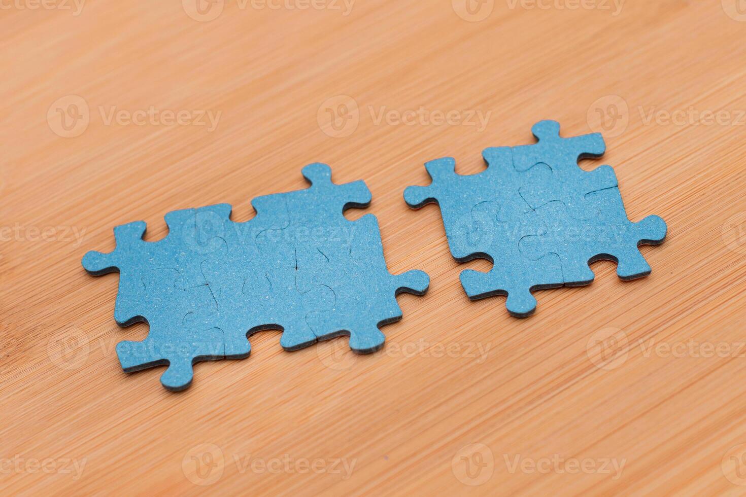 Top View of a Blue Puzzle Pieces Lie on the Wooden Table photo