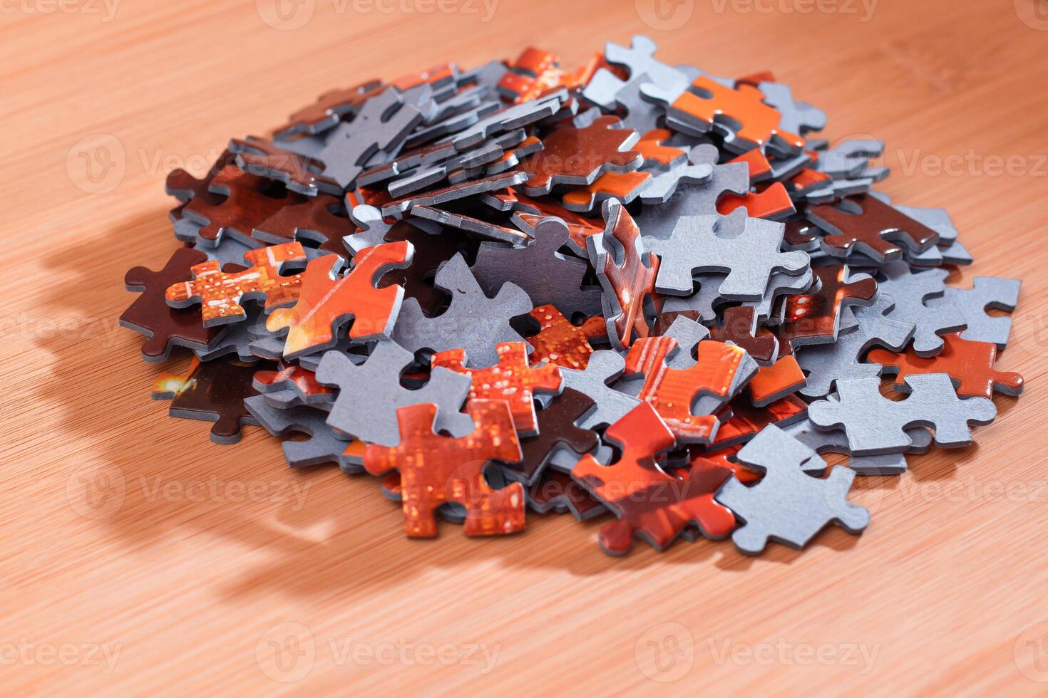Colorful Pieces of a Mixed Jigsaw Puzzle Lie on the Wooden Table - Strategy and Solving Problem Concept photo