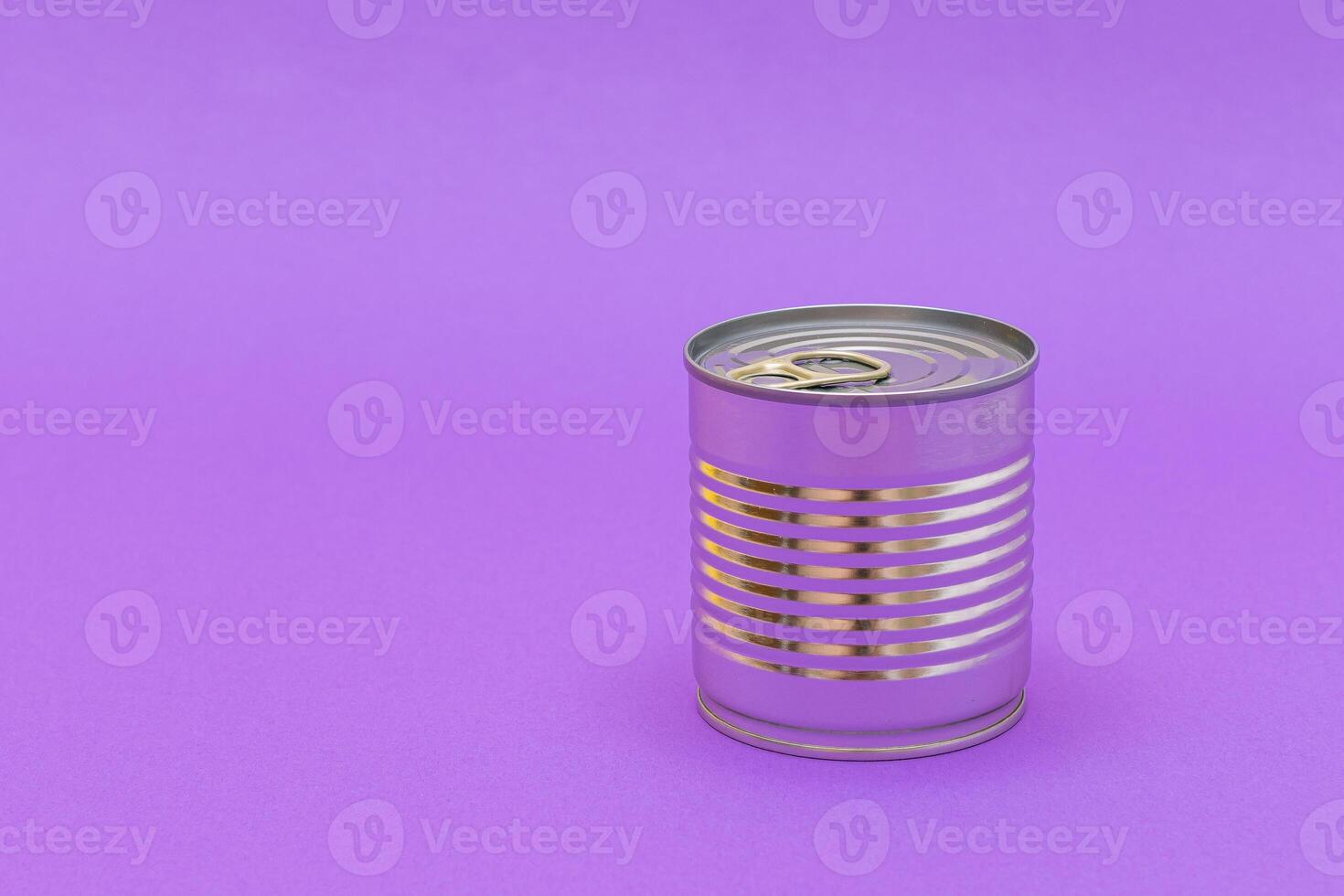 Unopened Tin Can with Blank Edge on Violet Background. Canned Food. Aluminum Can for Safe and Long Term Storage of Food. Steel Sealed Food Storage Container photo