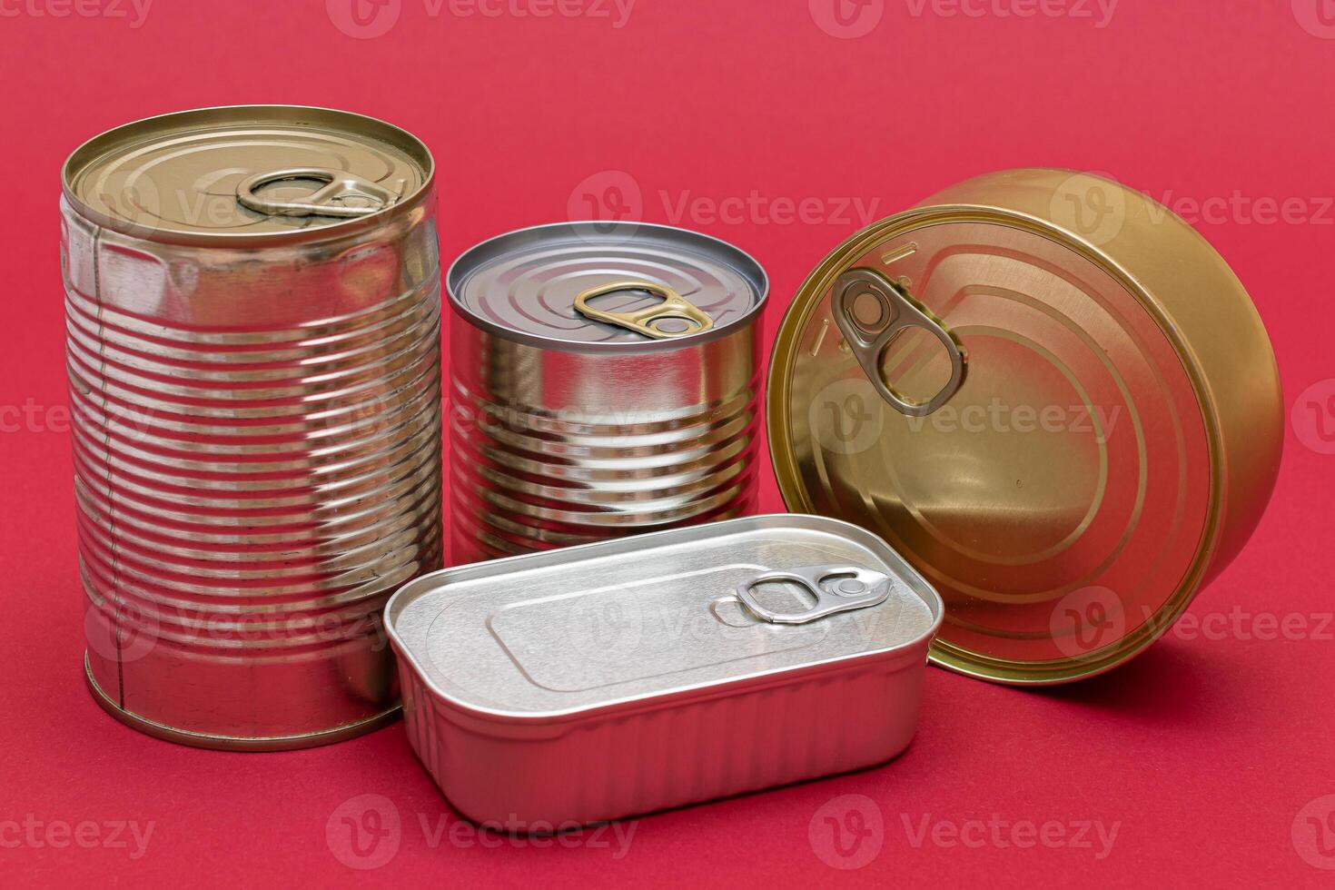 A Group of Stacked Tin Cans with Blank Edges on Red Background. Canned Food. Different Aluminum Cans for Safe and Long Term Storage of Food. Steel Sealed Food Storage Containers photo