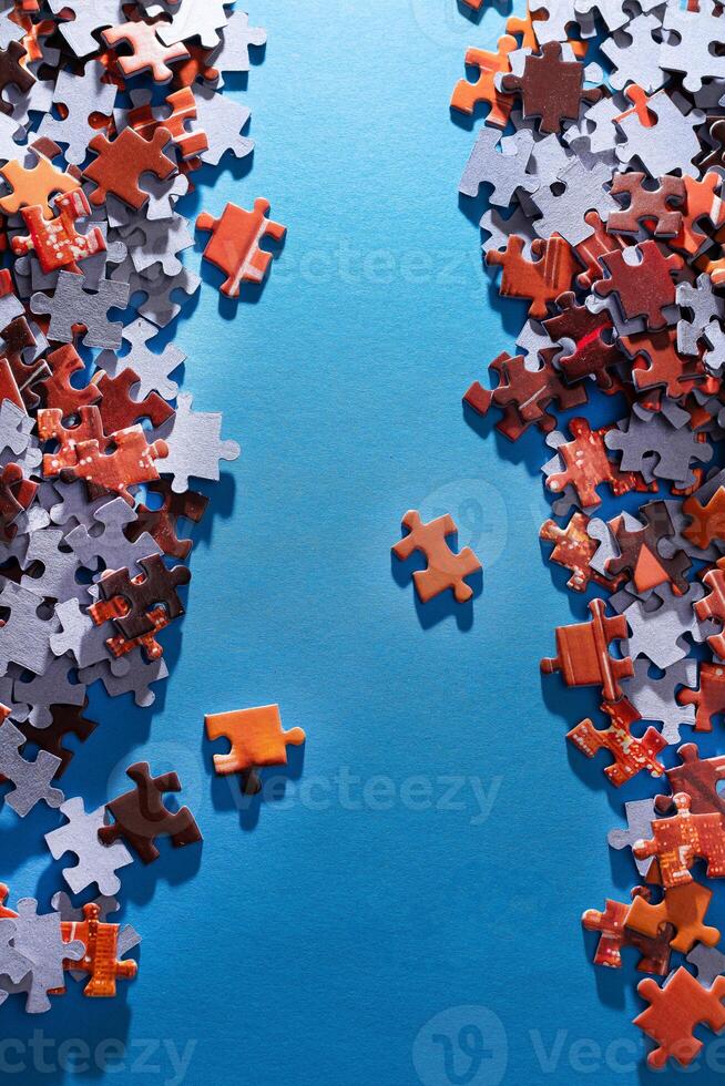 Mixed Pieces of a Colorful Jigsaw Puzzle Lie on the Blue Background - Strategy and Solving Problem Concept photo