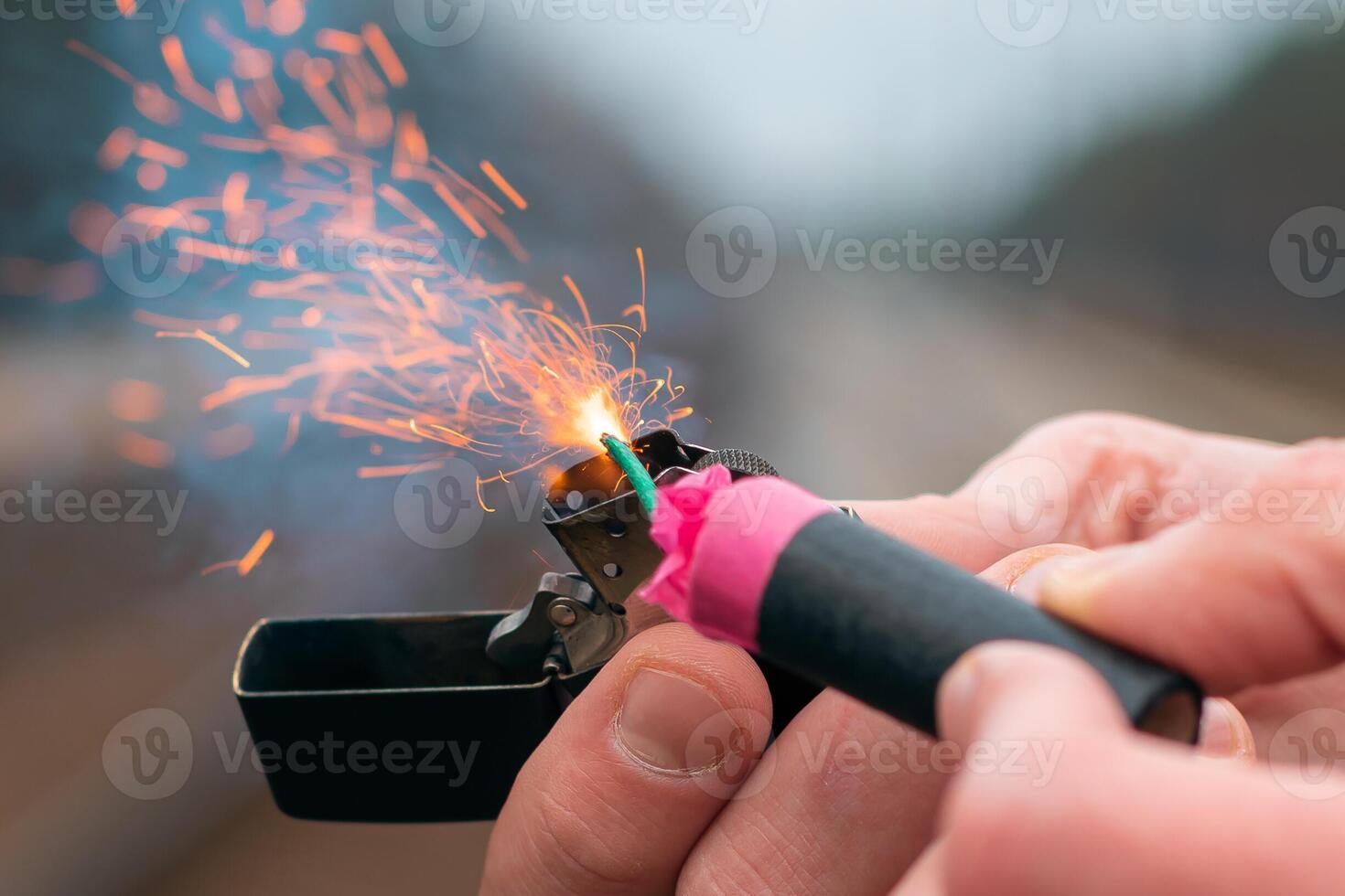 The Firecracker in a Hand. Man Holding a Burning Petard in His Hand. A Human with a Pyrotechnics that Burns with Sparks and Smoke Outdoors photo