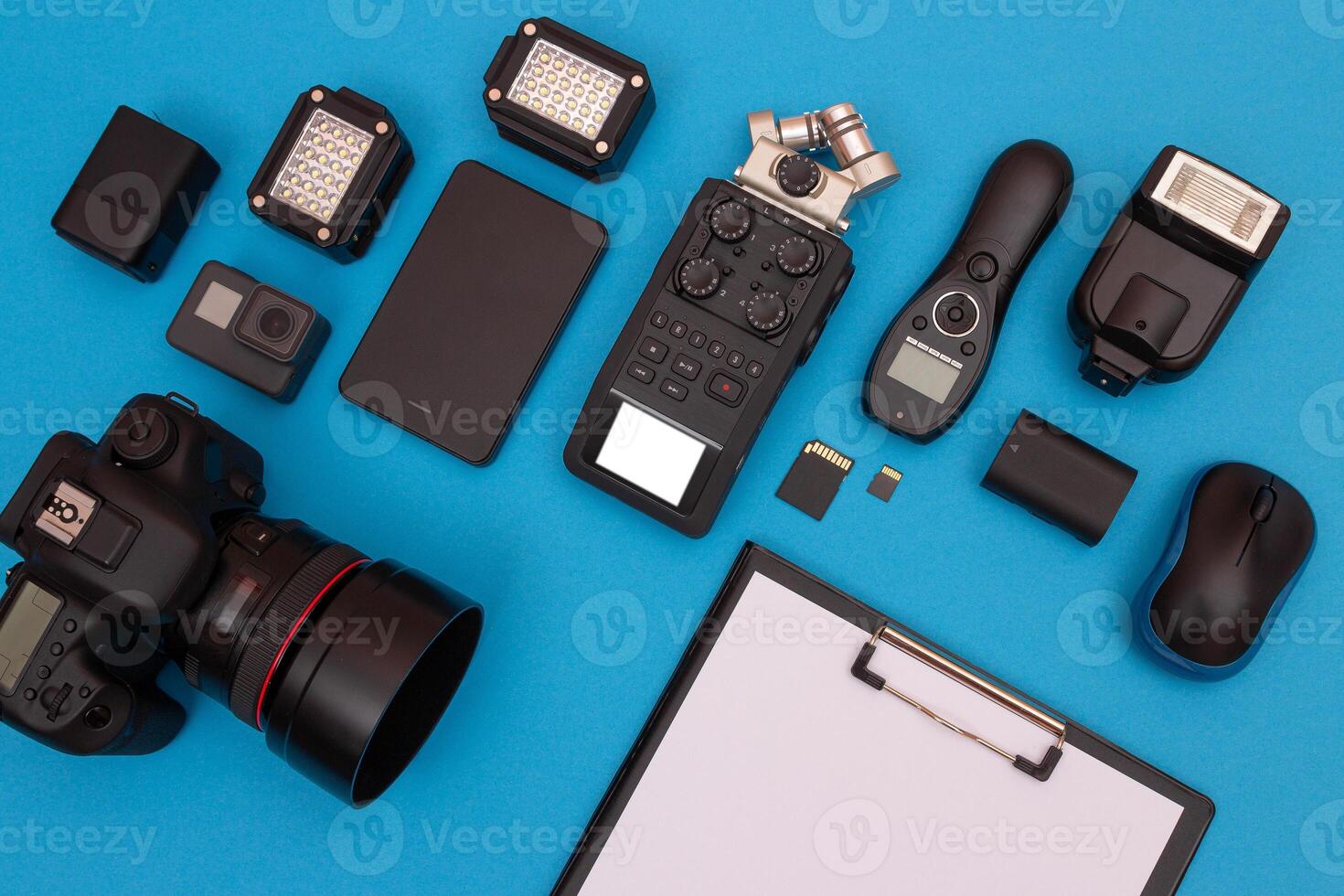 Top View of Photographer's, Videographer's or Blogger's Workplace. Digital Gadgets Lying on Blue Table - Flat Lay photo