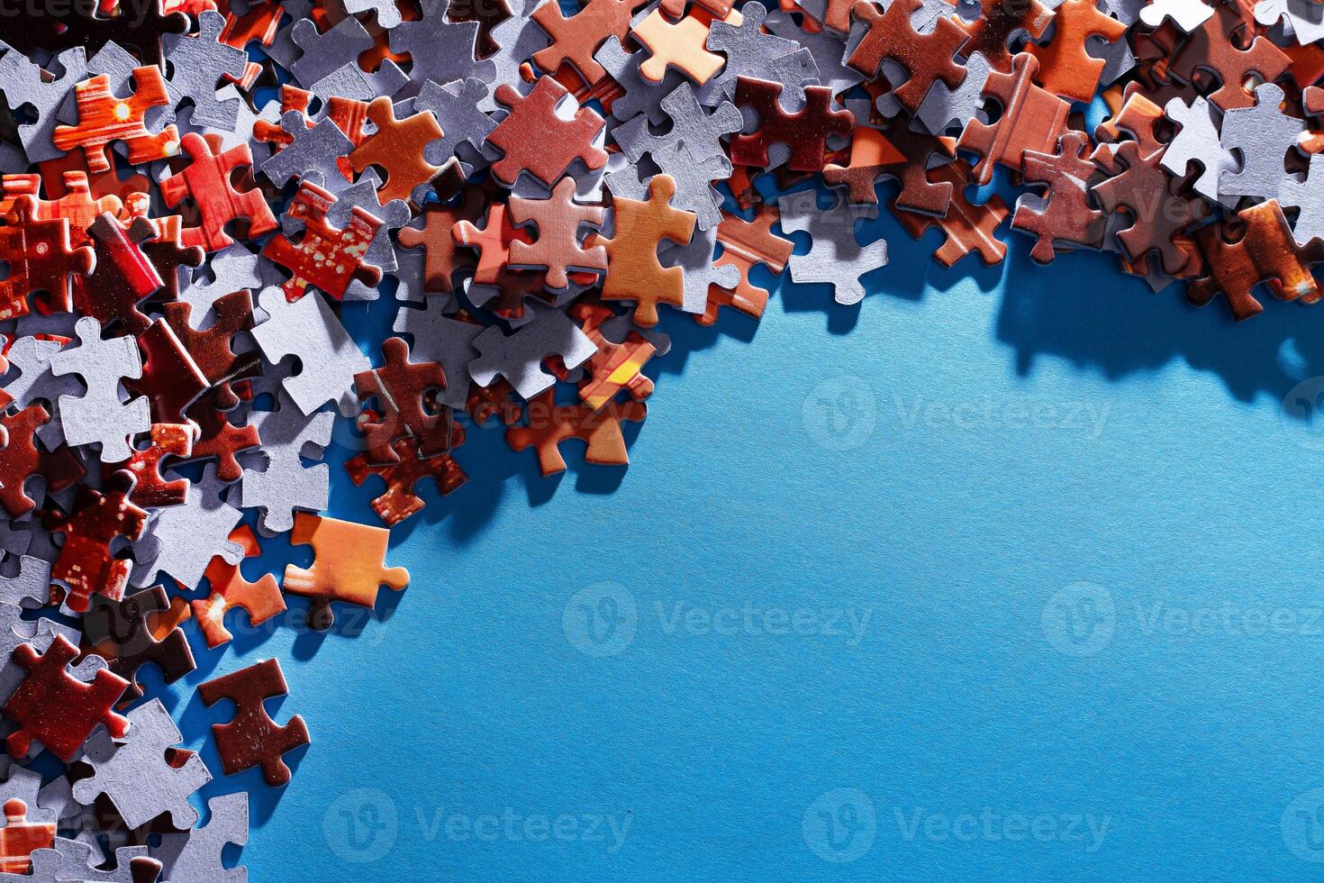 Mixed Pieces of a Colorful Jigsaw Puzzle Lie on the Blue Background With Copy Space - Strategy and Solving Problem Concept photo