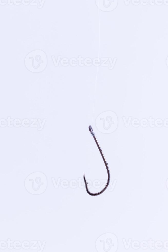 Black Fishing Hook Hanging on a Fishing Line Against a White Background photo