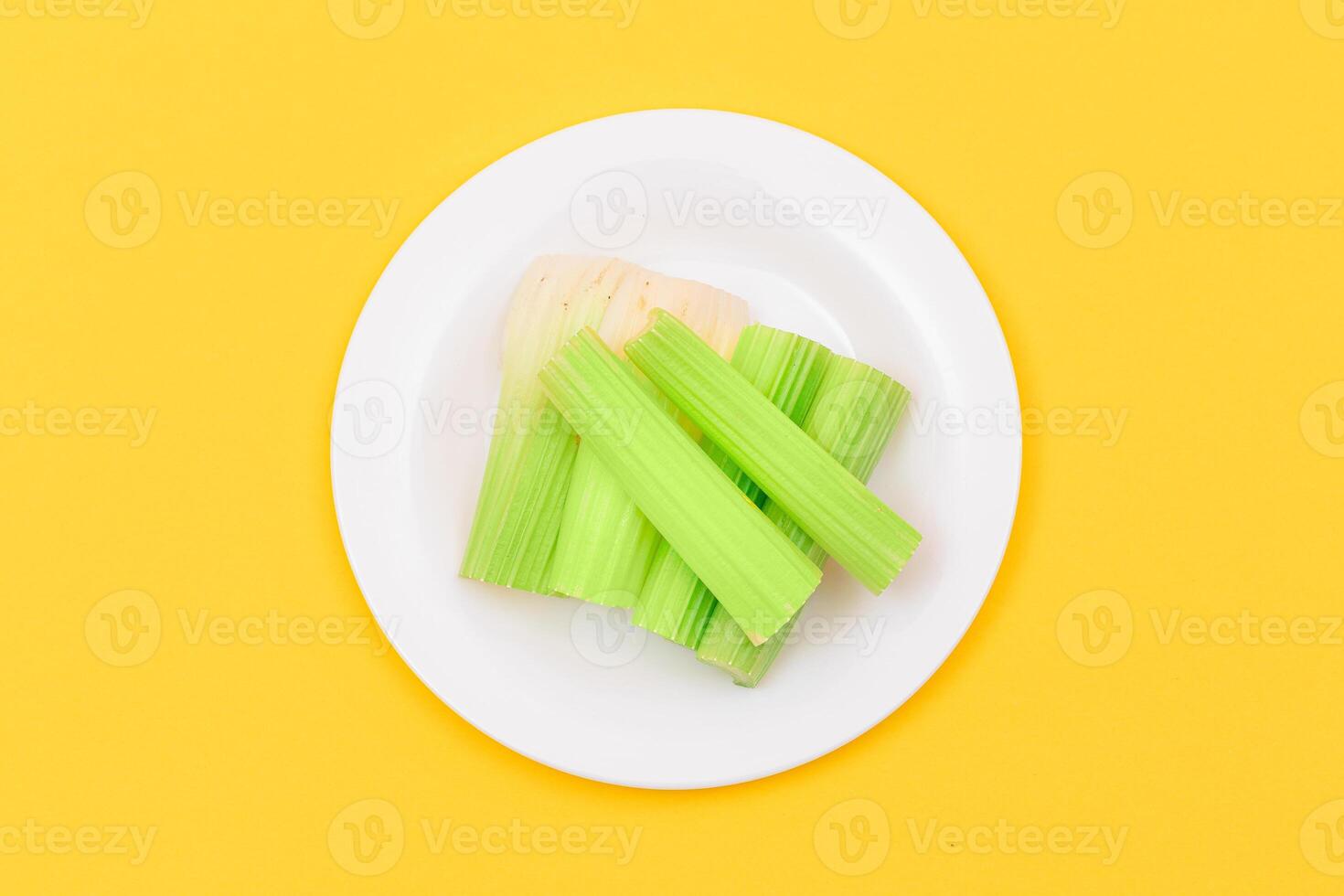 Fresh Chopped Celery Sticks on White Dish. Vegan and Vegetarian Culture. Raw Food. Healthy Diet with Negative Calorie Content photo