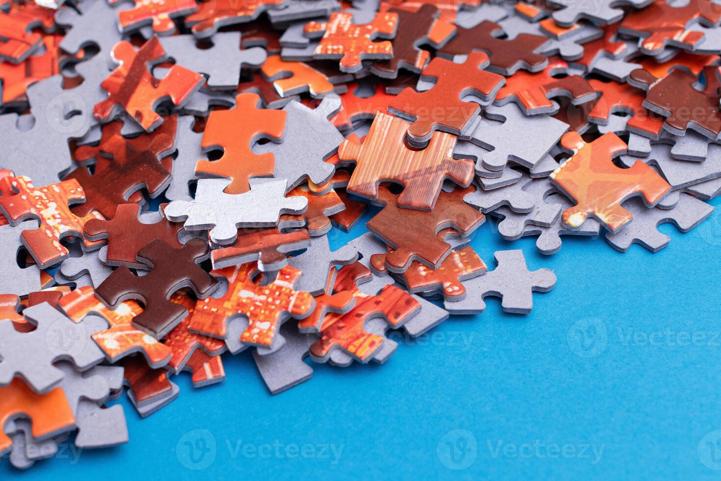Mixed Pieces of a Colorful Jigsaw Puzzle Lie on the Blue Background - Strategy and Solving Problem Concept photo