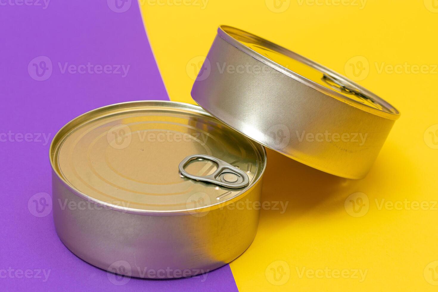 A Group of Stacked Tin Cans with Blank Edges on Split Yellow and Violet Background. Canned Food. Different Aluminum Cans for Safe and Long Term Storage of Food. Steel Sealed Food Storage Containers photo