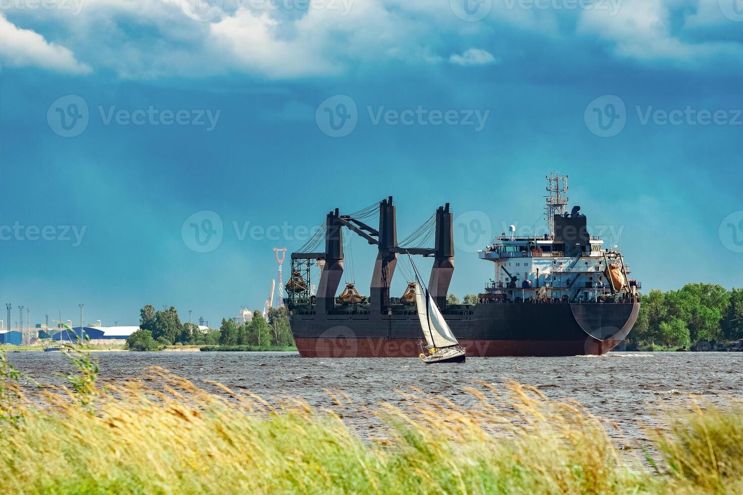 Merchandise import. Large blue cargo ship moving to Riga port photo