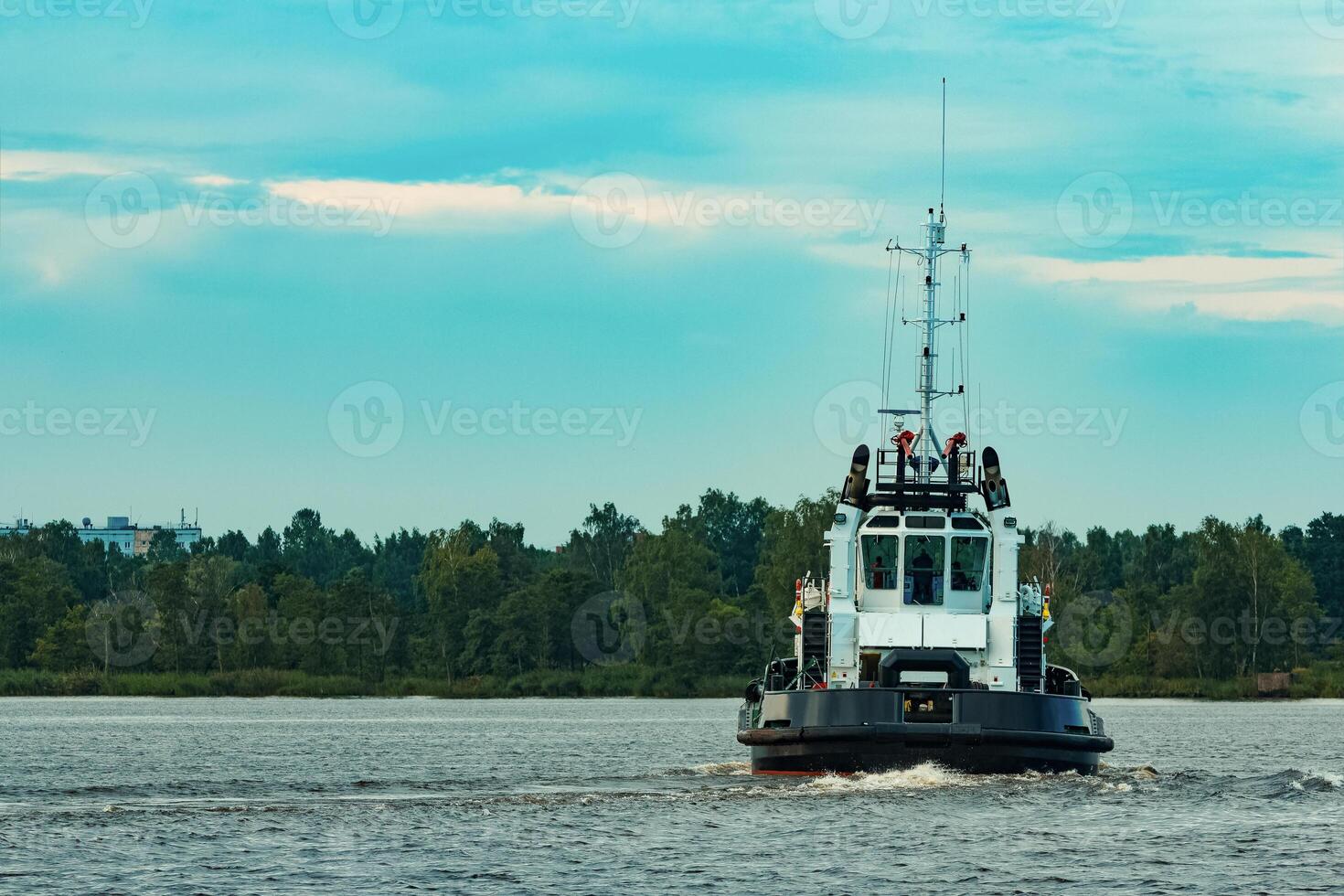 Black tug ship moving to the cargo terminal. Industrial service photo