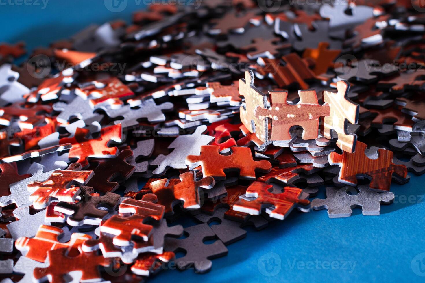 Mixed Pieces of a Colorful Jigsaw Puzzle Lie on the Blue Background - Strategy and Solving Problem Concept photo