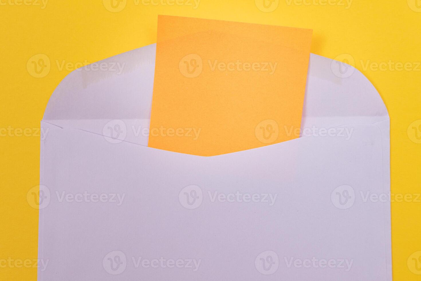Violet Envelope with Blank Orange Sheet of Paper Inside, Lying on Yellow Background - Mock Up with Copy Space. Receiving Mail or Notice, Sending Postcard - Top View, Flat Lay photo