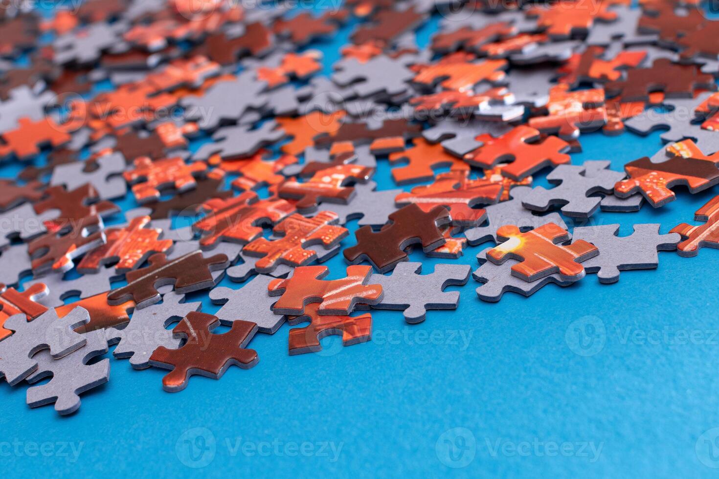 Mixed Pieces of a Colorful Jigsaw Puzzle Lie on the Blue Background - Strategy and Solving Problem Concept photo