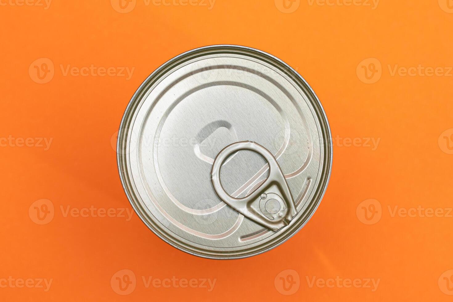 Unopened Tin Can with Blank Edge on Orange Background. Canned Food. Aluminum Can for Safe and Long Term Storage of Food. Steel Sealed Food Storage Container photo