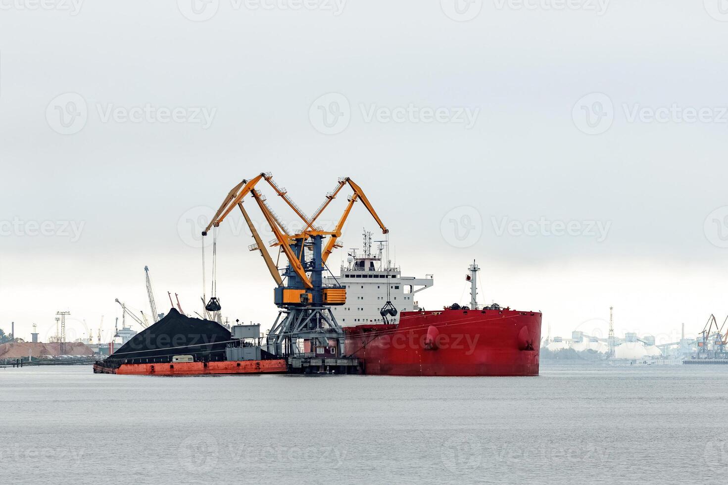 Large red cargo ship loading with a coal in the port photo