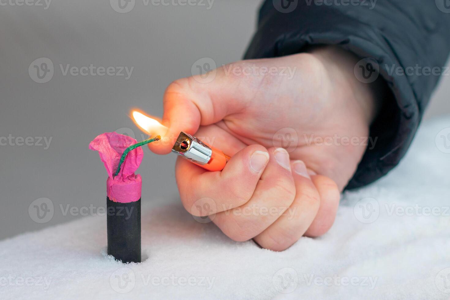 Guy Sets Fire to the Flash Noise Firecracker Outdoors in Winter at Daytime. Loud and Dangerous New Year's Entertainment. Hooliganism with Pyrotechnics. Noise of Petards in Public Places photo