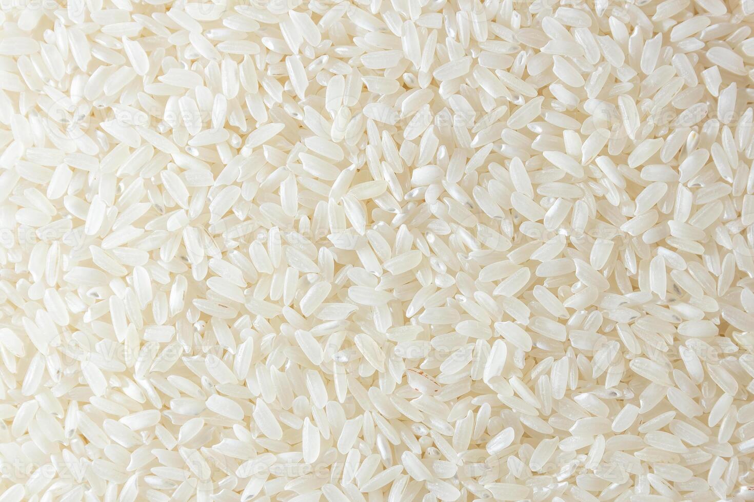Dry Uncooked White Rice Background - Top View, Flat Lay. Scattered Raw Long Grain Rice. Asian Cuisine and Culture. Healthy Eating Ingredients. Diet Food photo