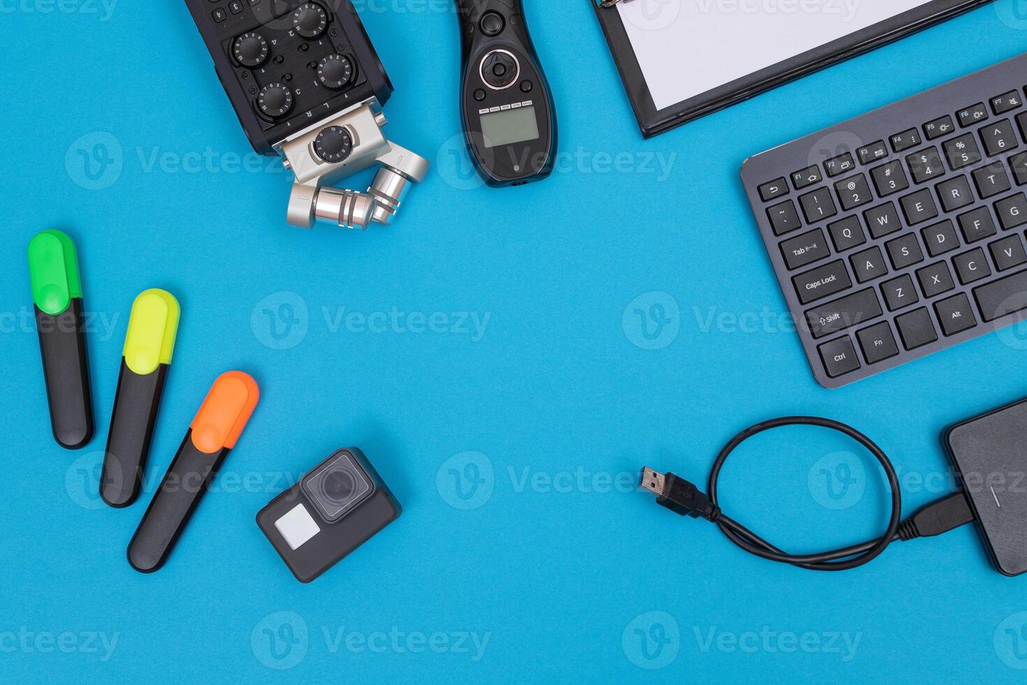 Top View of Photographer's, Videographer's or Blogger's Workplace. Digital Gadgets Lying on Blue Table - Flat Lay photo