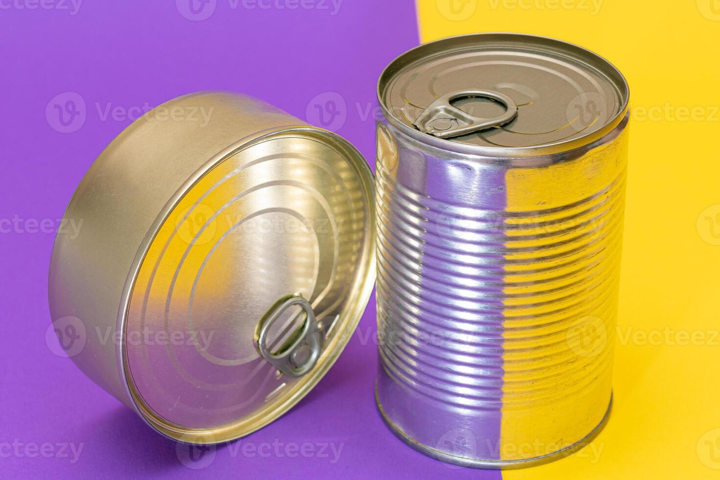 A Group of Stacked Tin Cans with Blank Edges on Split Yellow and Violet Background. Canned Food. Different Aluminum Cans for Safe and Long Term Storage of Food. Steel Sealed Food Storage Containers photo