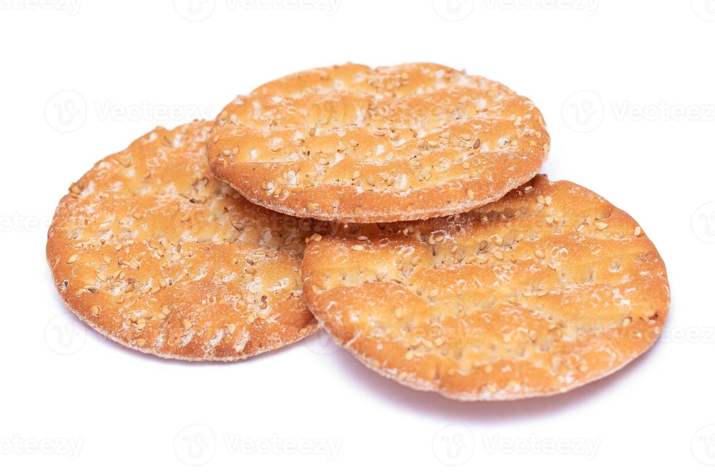 A Heap of Round Salt Crackers with Sesame Isolated on White Background. Dry Snacks - Isolation photo