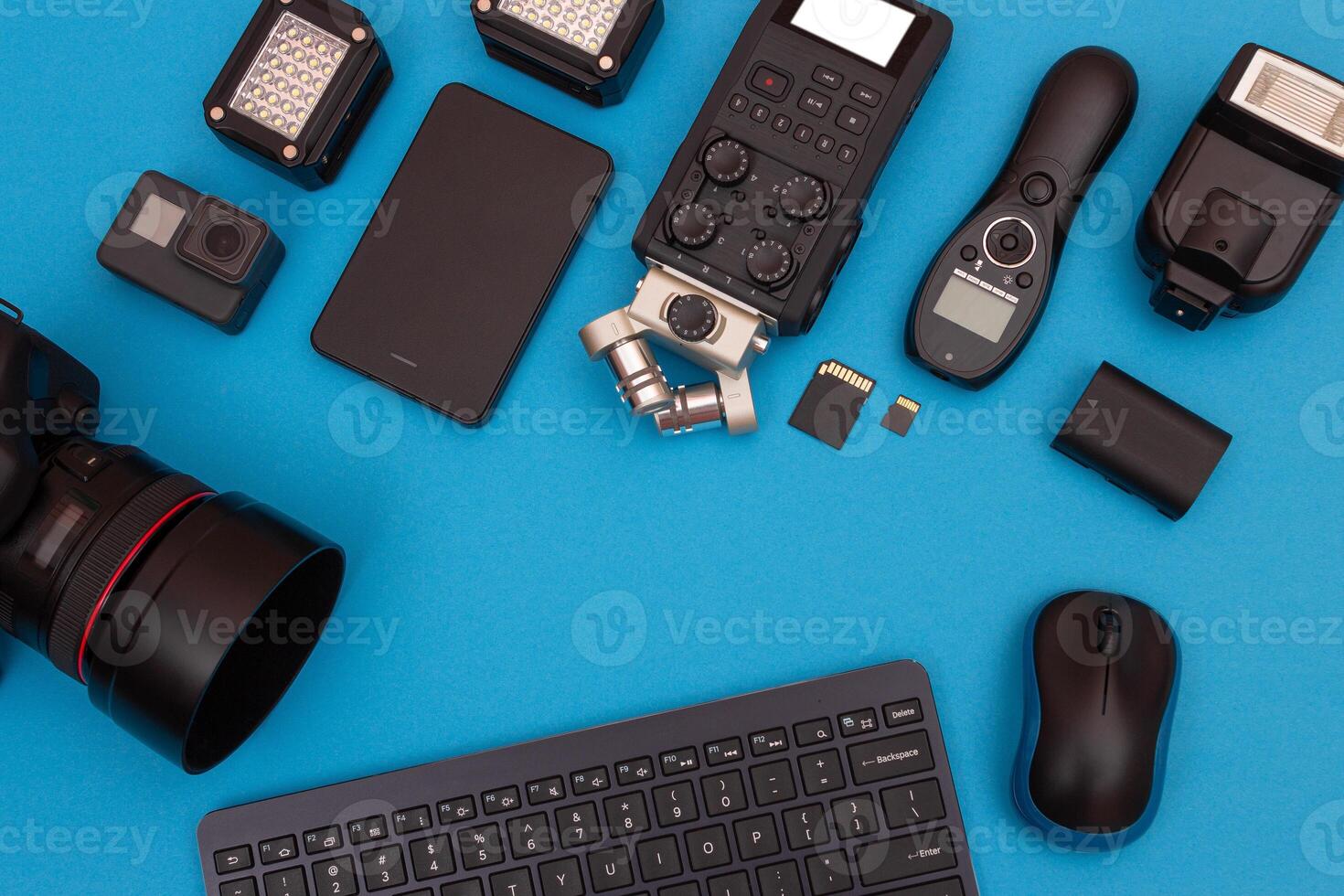 Top View of Photographer's, Videographer's or Blogger's Workplace. Digital Gadgets Lying on Blue Table - Flat Lay photo