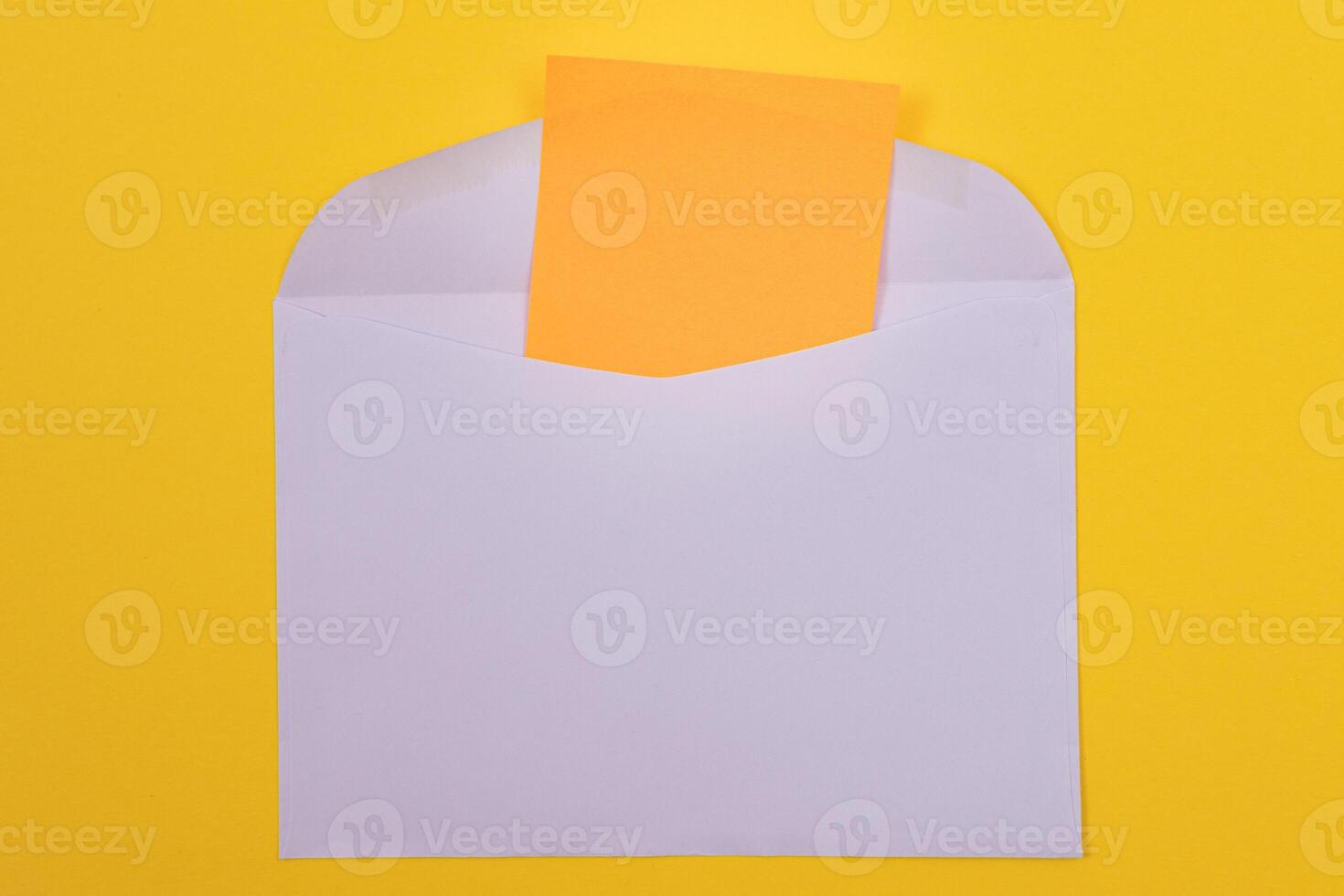 Violet Envelope with Blank Orange Sheet of Paper Inside, Lying on Yellow Background - Mock Up with Copy Space. Receiving Mail or Notice, Sending Postcard - Top View, Flat Lay photo