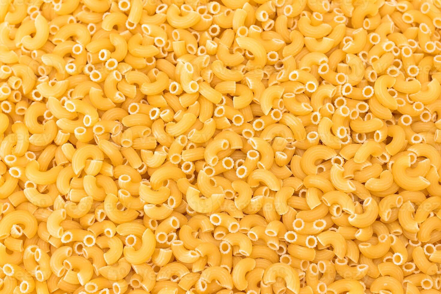 Uncooked Chifferi Rigati Pasta Background. Fat and Unhealthy Food. Classic Dry Macaroni Texture. Italian Culture and Cuisine. Raw Pasta photo