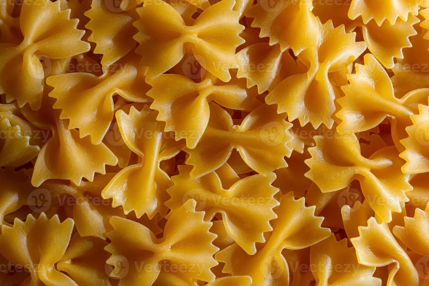 Uncooked Farfalle Pasta. A Culinary Canvas of Bow-Tie Macaroni, Creating a Lively and Textured Background for Gourmet Cooking. Dry Pasta. Raw Macaroni - Top View, Flat Lay photo