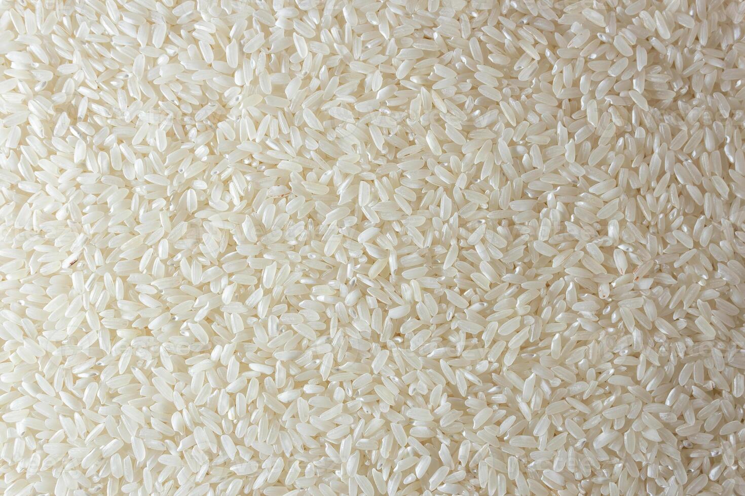 Dry Uncooked White Rice Background - Top View, Flat Lay. Scattered Raw Long Grain Rice. Asian Cuisine and Culture. Healthy Eating Ingredients. Diet Food photo