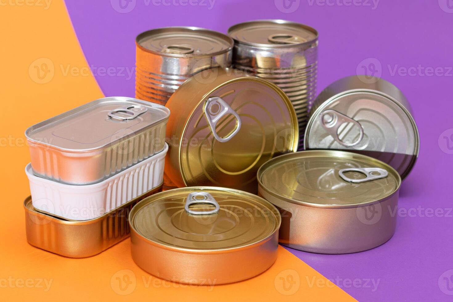 A Group of Stacked Tin Cans with Blank Edges on Split Orange and Violet Background. Canned Food. Different Aluminum Cans for Safe and Long Term Storage of Food. Steel Sealed Food Storage Containers photo
