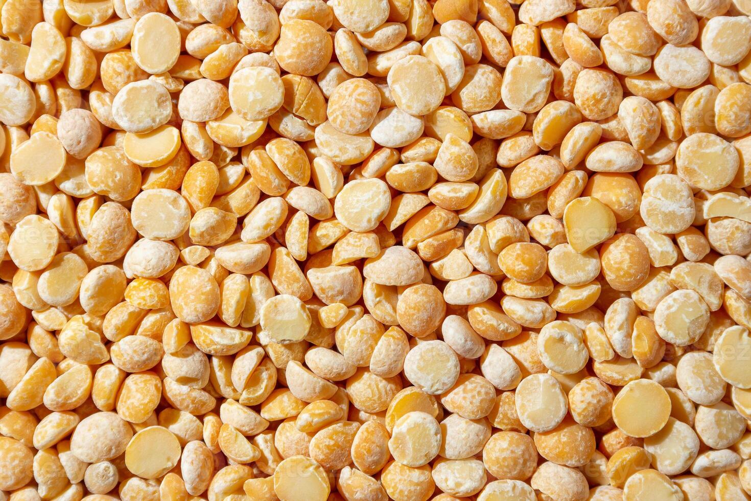 Uncooked Polished Split Peas Background. A Culinary Canvas of Dry Yellow Peas, Creating a Lively and Textured Background for Gourmet Cooking. Scattered Raw Polished Peas. Healthy Eating Ingredients photo