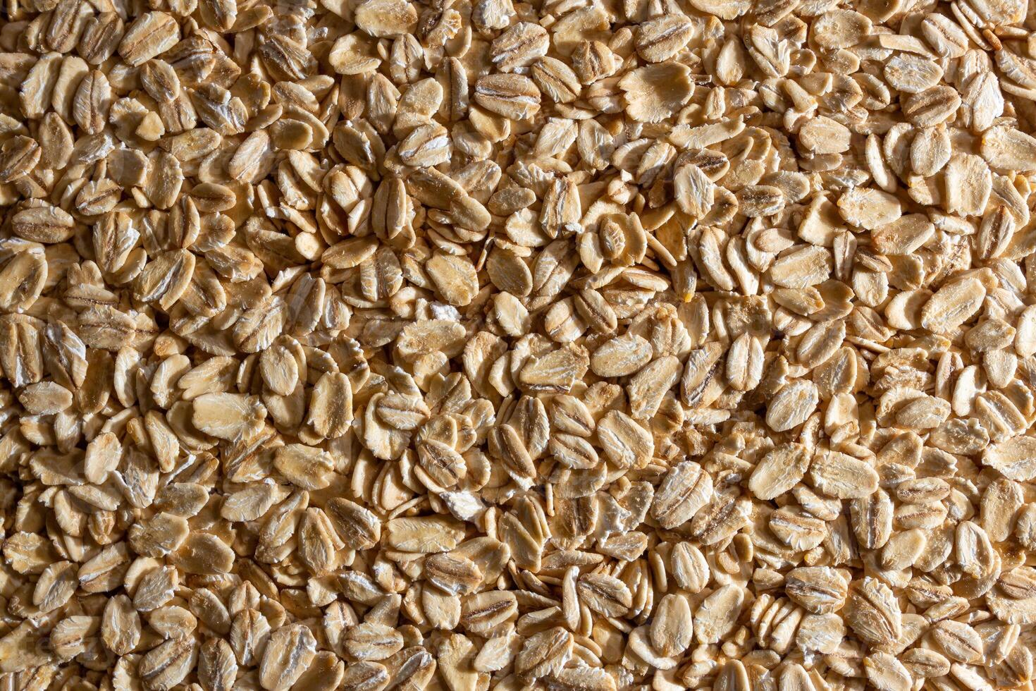Uncooked Oat Flakes background - Top View, Flat Lay. Scattered Dry and Raw Oat Flakes. Healthy Breakfast and Diet Eating Ingredients photo
