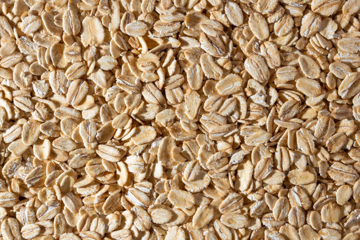 Uncooked Oat Flakes background - Top View, Flat Lay. Scattered Dry and Raw Oat Flakes. Healthy Breakfast and Diet Eating Ingredients photo