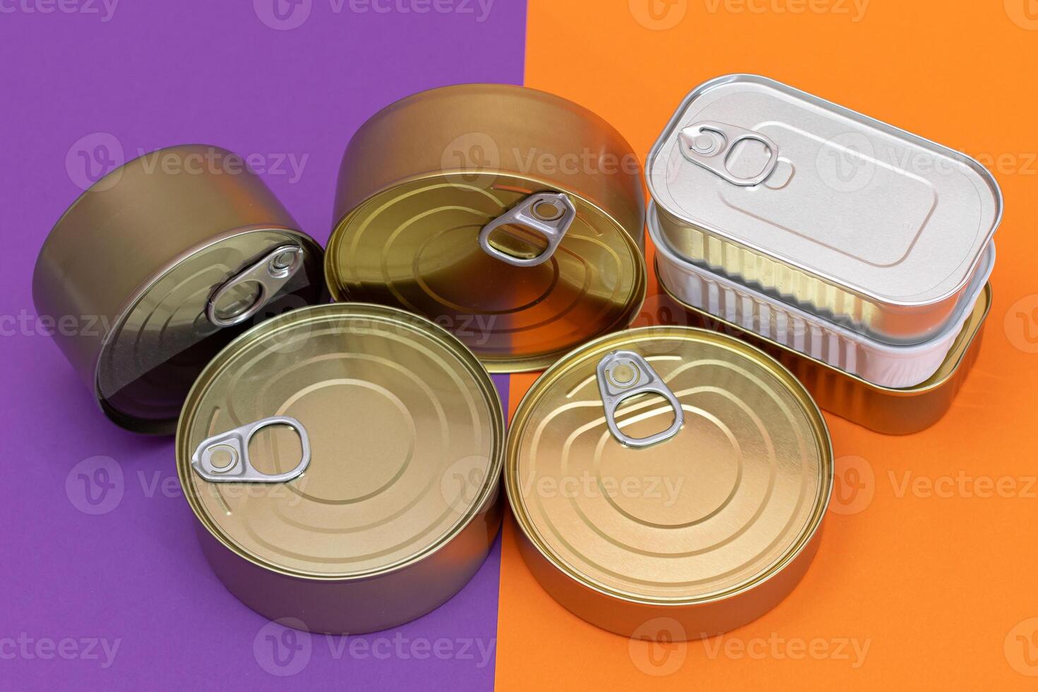 A Group of Stacked Tin Cans with Blank Edges on Split Orange and Violet Background. Canned Food. Different Aluminum Cans for Safe and Long Term Storage of Food. Steel Sealed Food Storage Containers photo