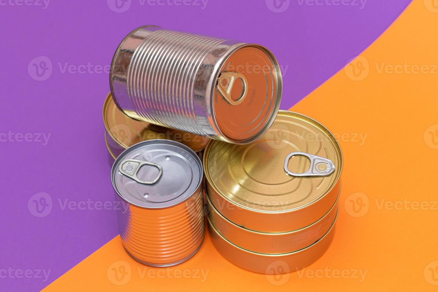 A Group of Stacked Tin Cans with Blank Edges on Split Orange and Violet Background. Canned Food. Different Aluminum Cans for Safe and Long Term Storage of Food. Steel Sealed Food Storage Containers photo