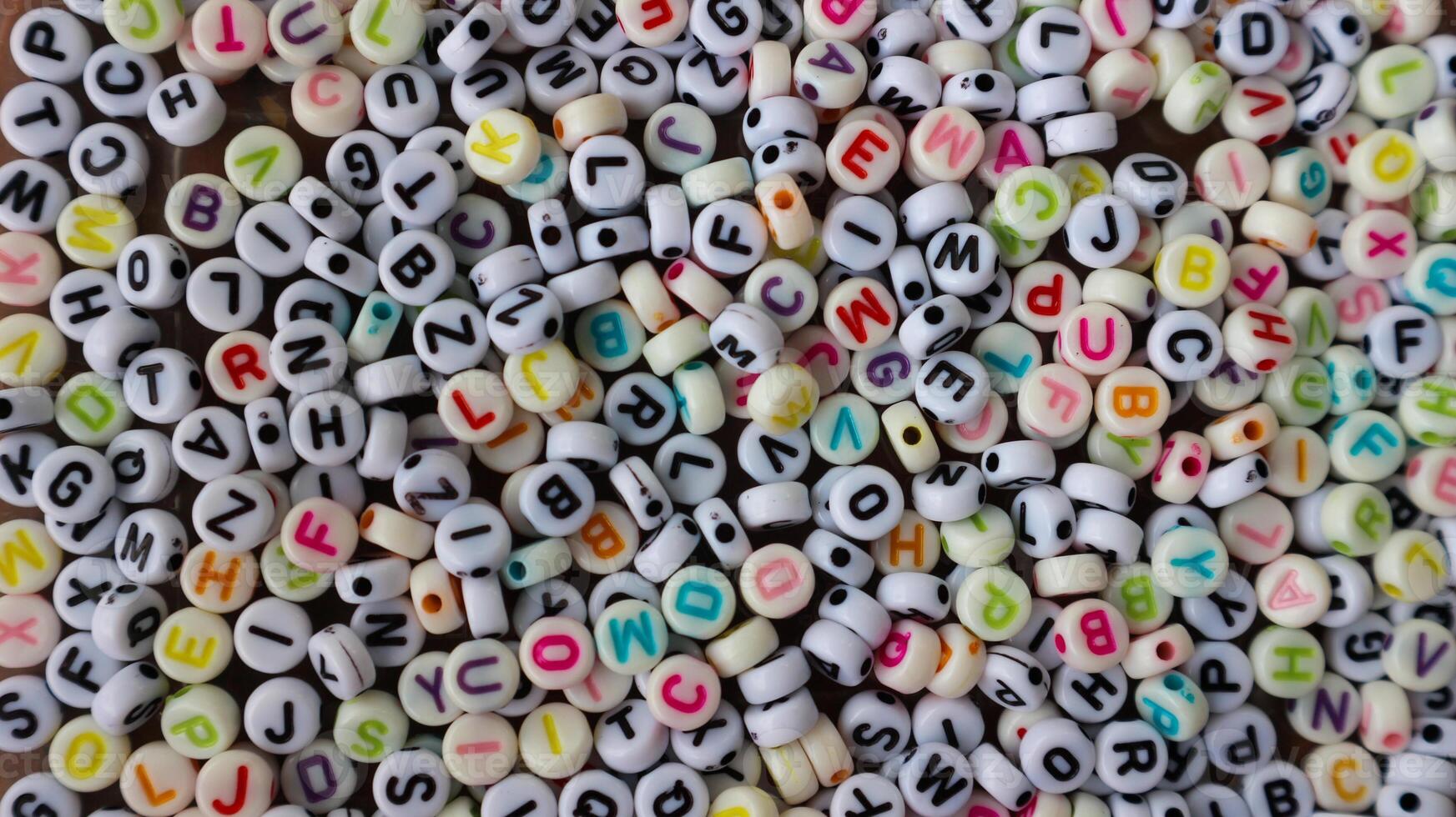 Collection of colourful beads blocks to make handmade jewellery bracelet names, in Rajasthan, India. heap of multi colored beads in an Indian street shop. Alphabets in kinder garden school for kids. photo