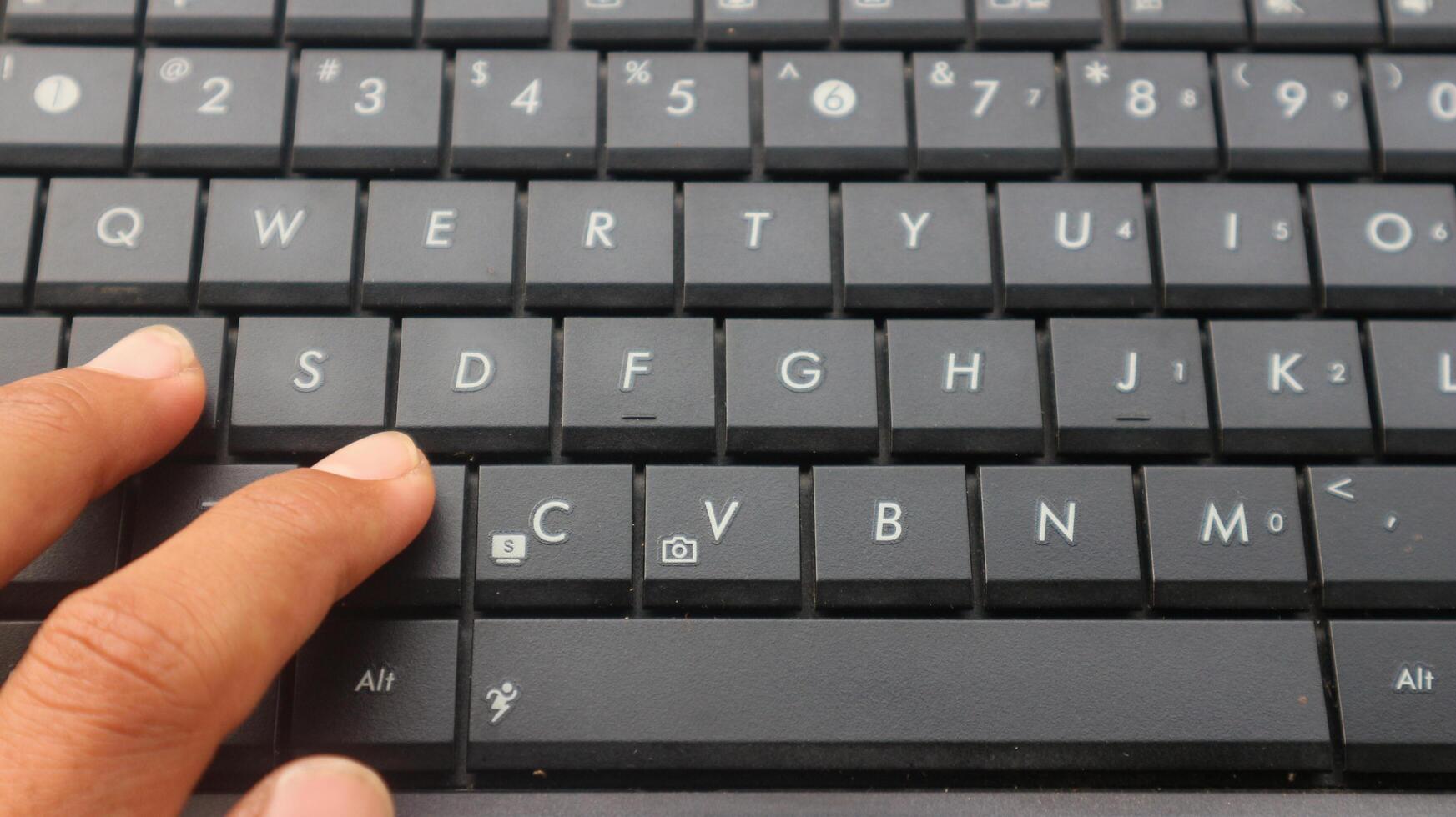 Close-up of a laptop keyboard. Fingers typing on the laptop keyboard. photo