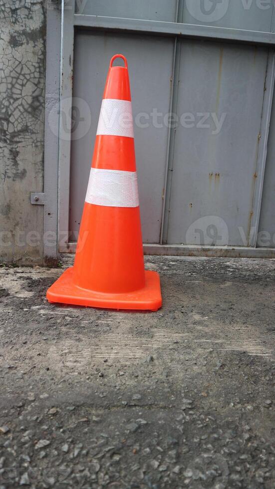 bright orange traffic cones standing in a row on dark asphalt photo