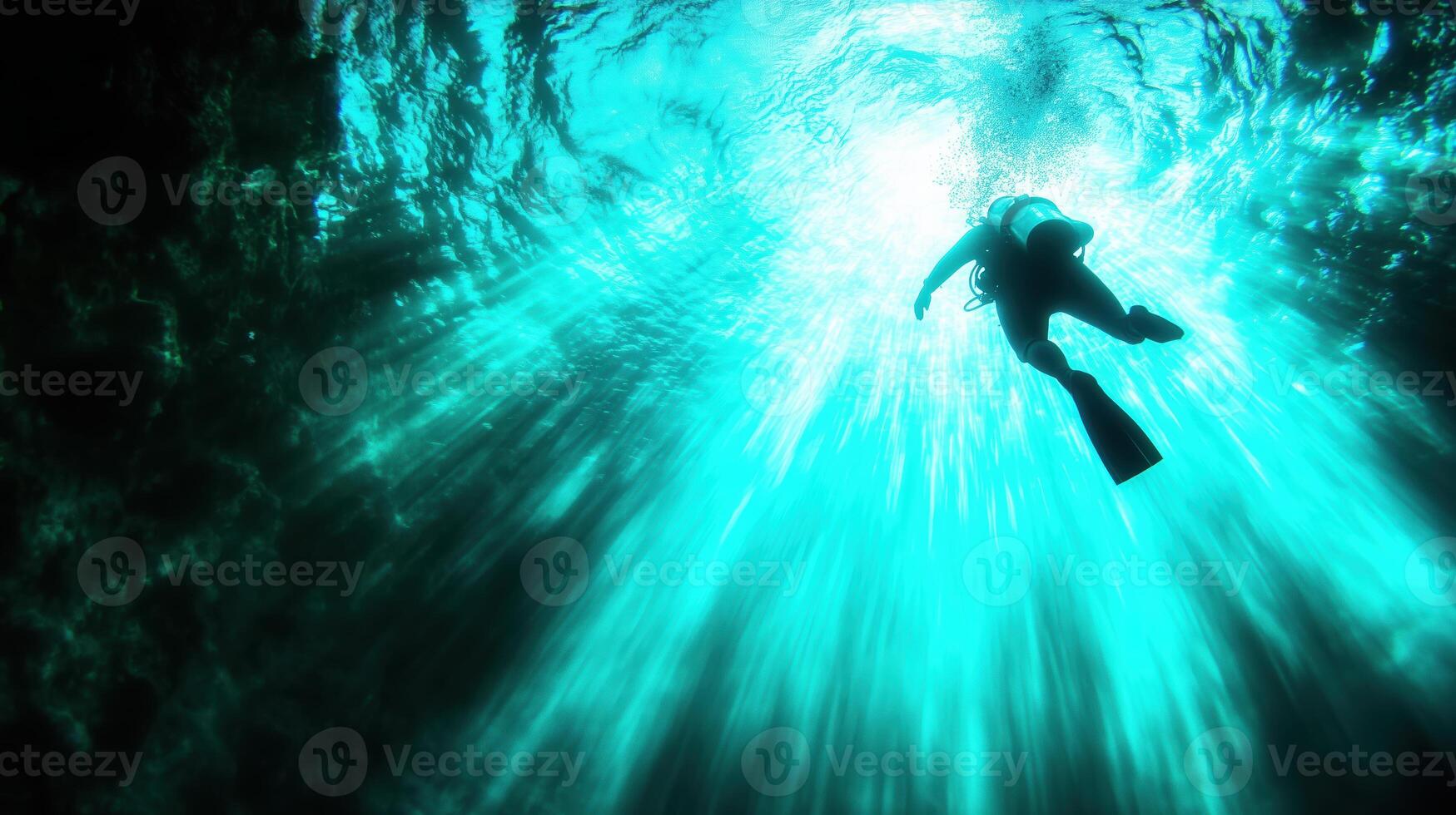 Diver exploring underwater depths, surrounded by vibrant blue light and shimmering water. serene atmosphere evokes sense of adventure and tranquility photo