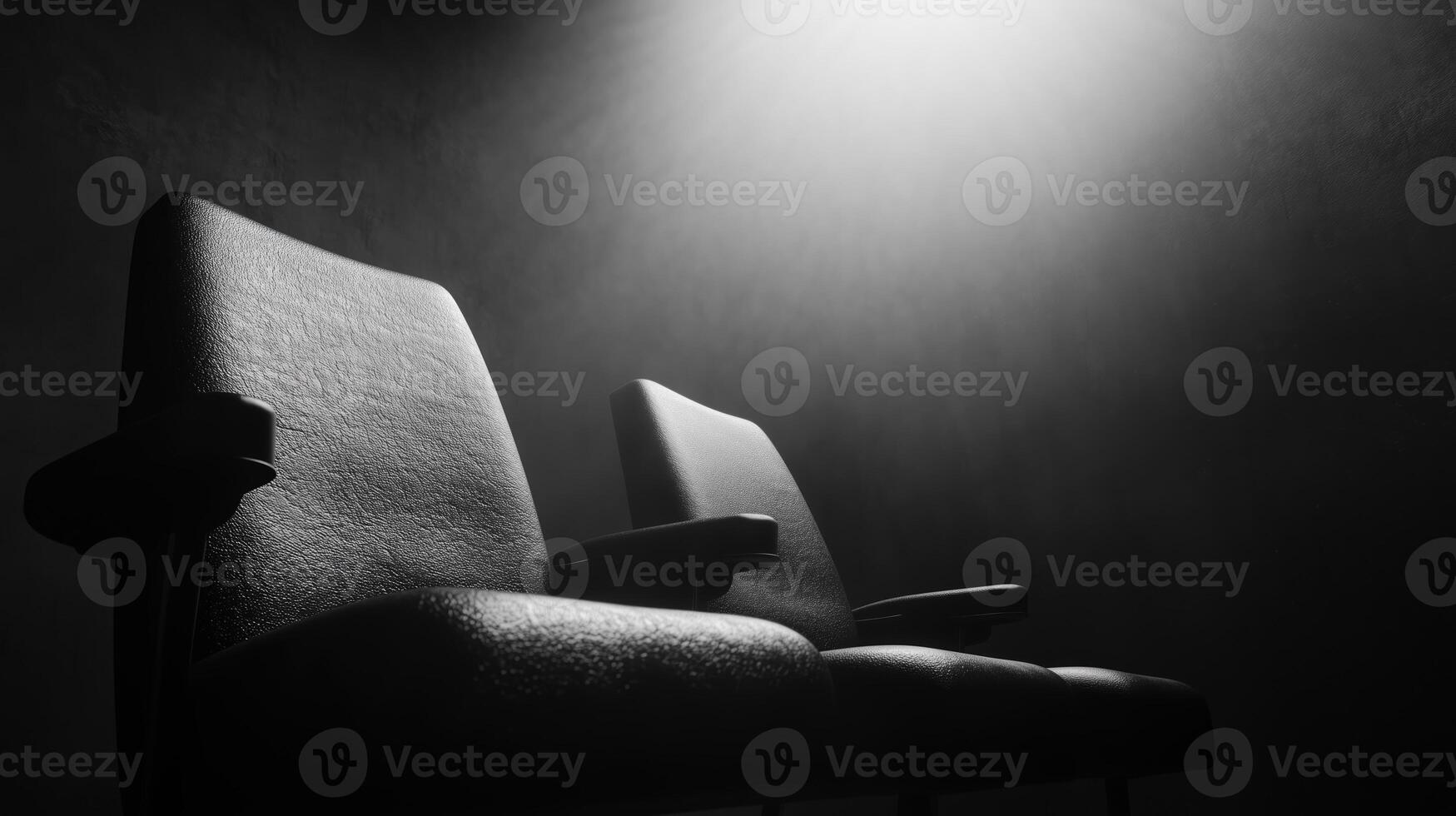 Two black chairs in dimly lit space create dramatic atmosphere, evoking sense of mystery and anticipation. shadows enhance mood of scene photo