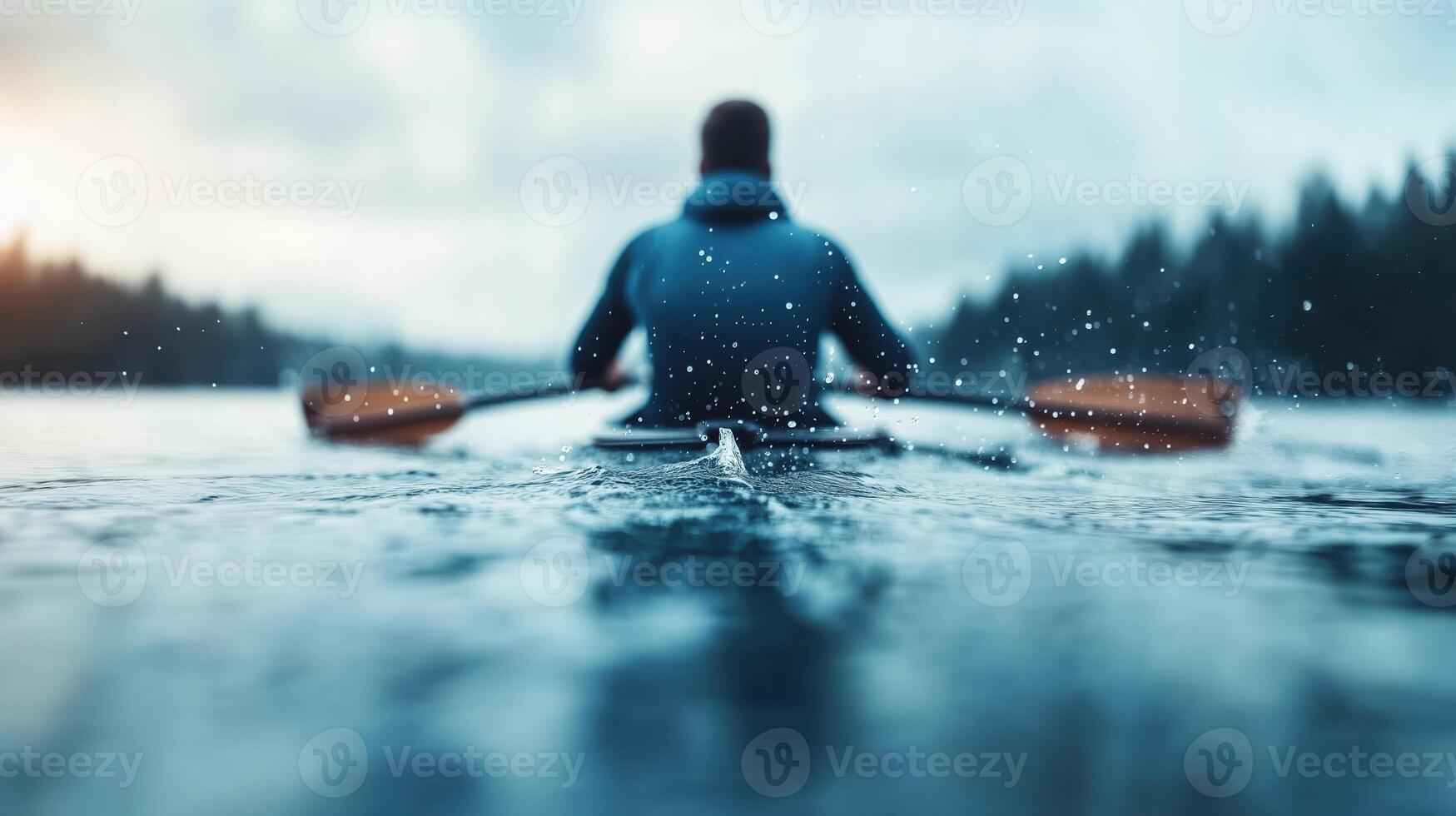 person is kayaking on serene lake, creating splashes as they paddle through calm water. scene captures beauty of nature and tranquility of outdoor activities photo