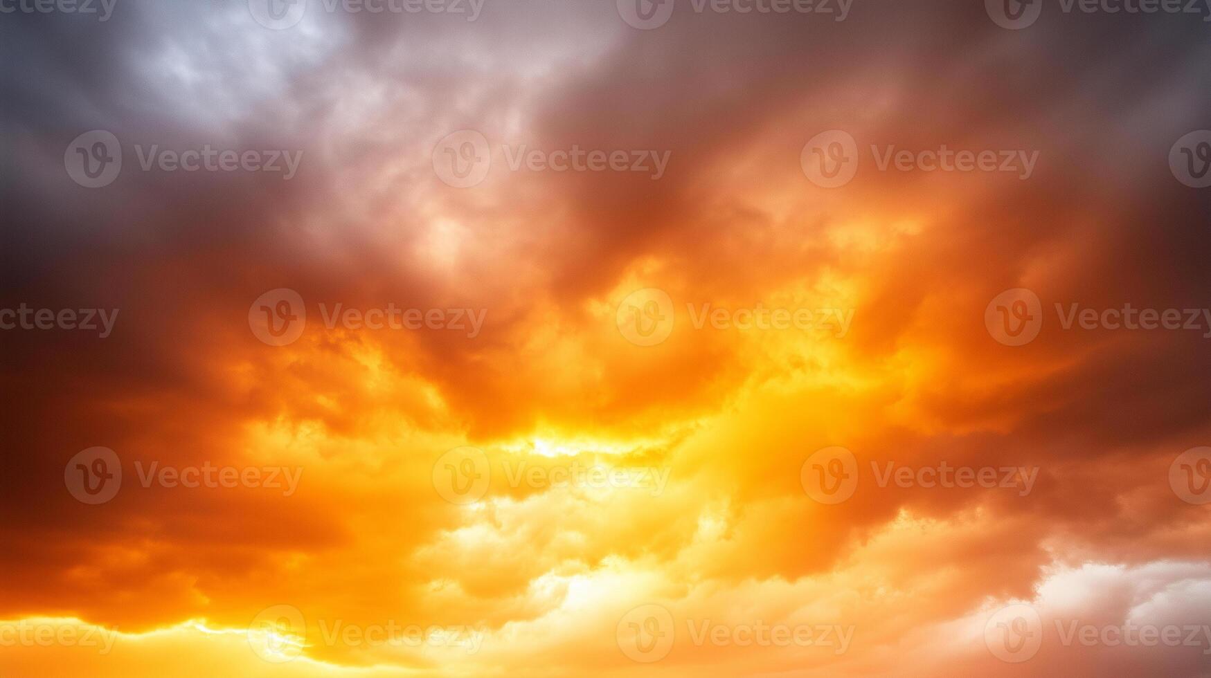 Breathtaking sunset clouds display vibrant hues of orange and gray, creating dramatic sky filled with swirling patterns and textures. scene evokes sense of wonder and tranquility photo