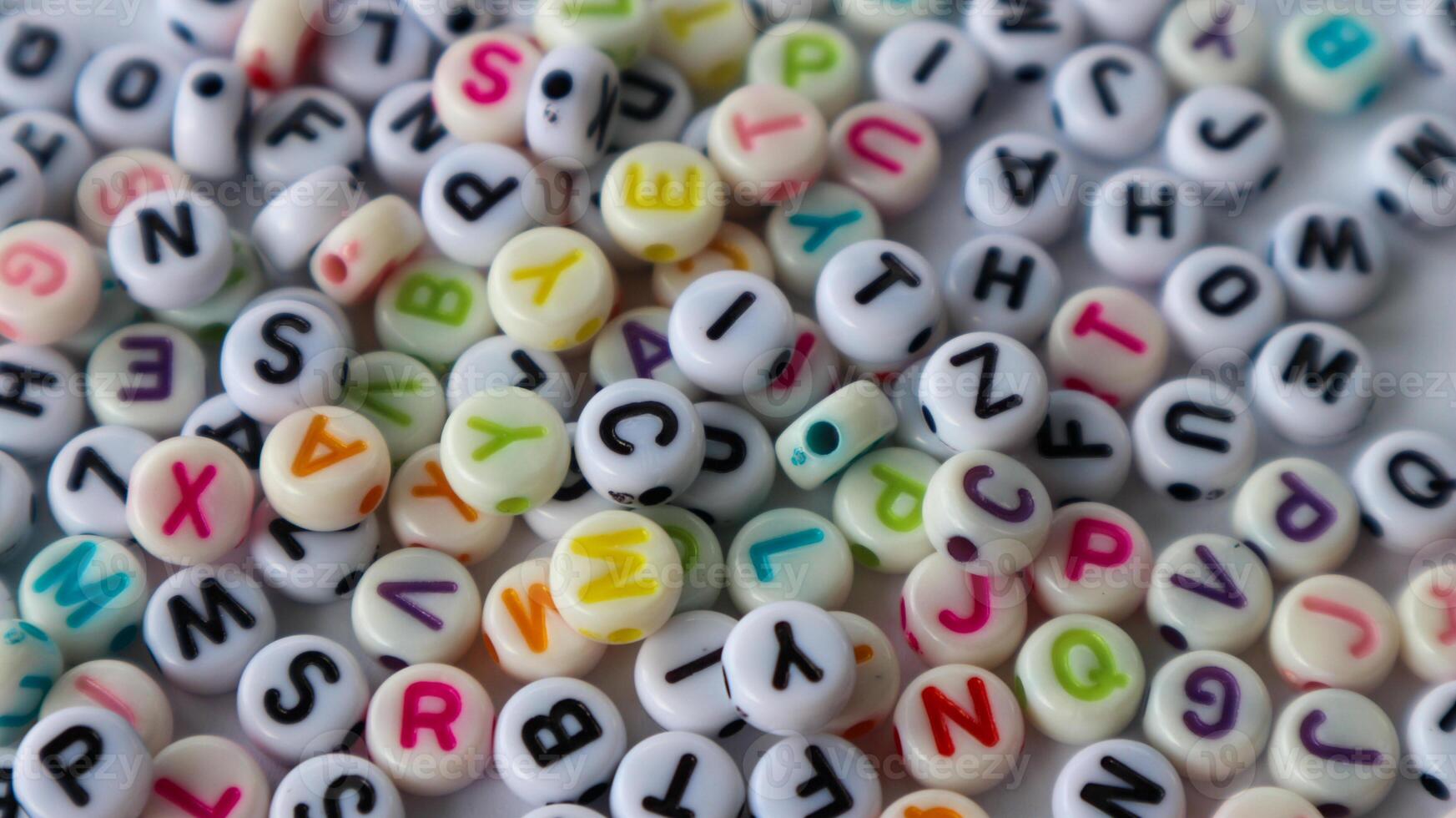 Collection of colourful beads blocks to make handmade jewellery bracelet names, in Rajasthan, India. heap of multi colored beads in an Indian street shop. Alphabets in kinder garden school for kids. photo