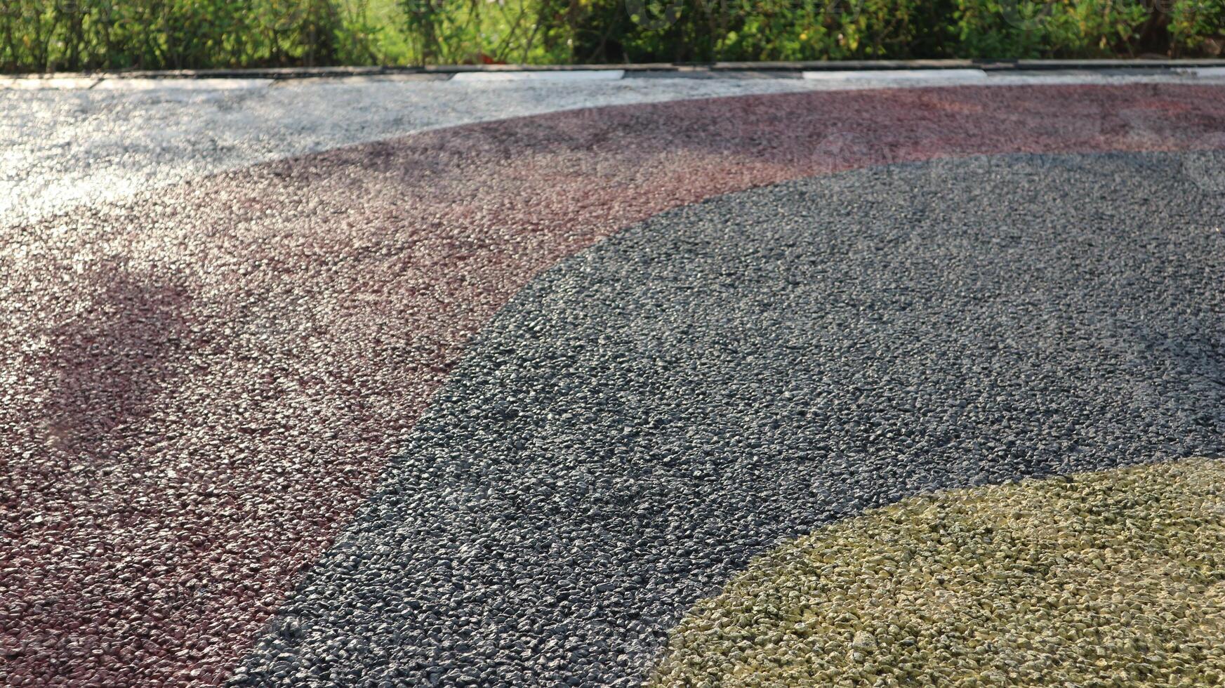Black asphalt. Pebble stone flooring with epoxy resin in city park. Pebble stone is yellow and red. photo