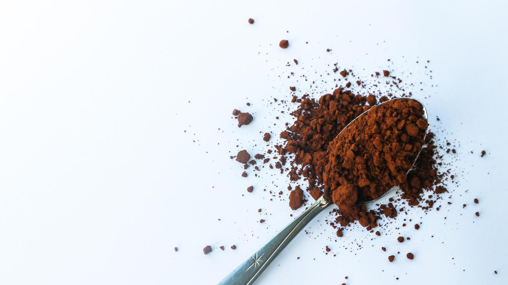 Coffee grounds in a spoon isolated on a white background. photo
