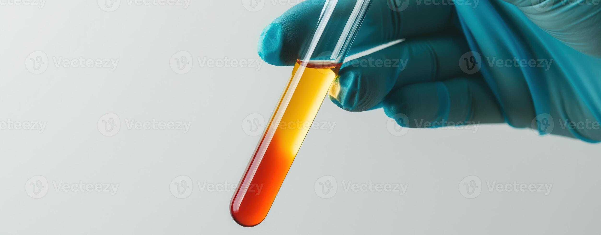 Gloved hand holding a test tube with yellow and red liquid for scientific research and analysis photo
